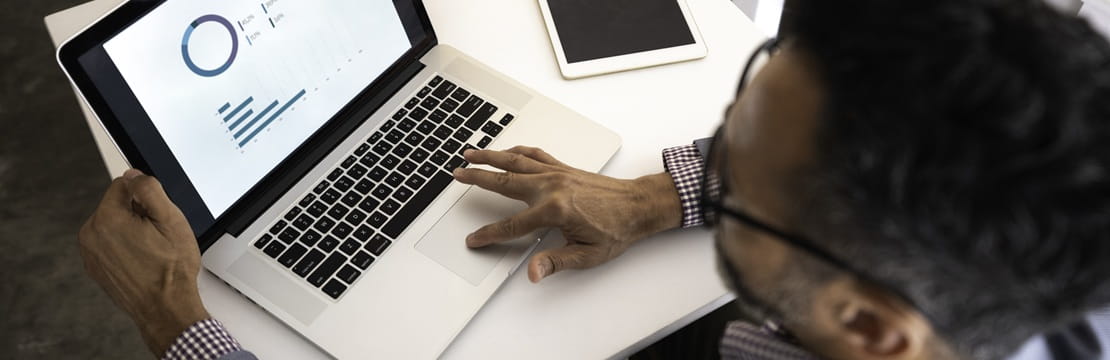 Business owner reviewing financial dashboards on a laptop, illustrating smart cash management to power business growth.